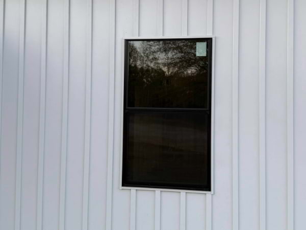 white board and batten siding with black windows