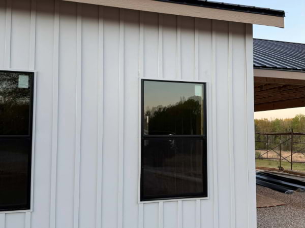 white board and batten siding with black windows