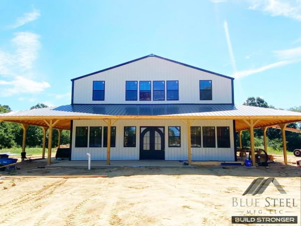 white and black barndominium with walk around porch