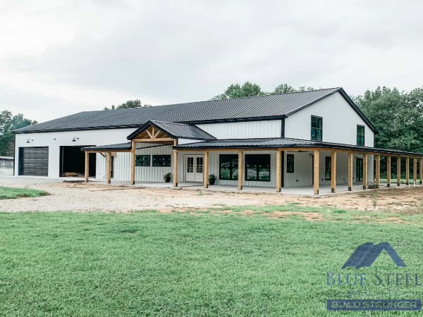 barndominium with white siding and black metal roof