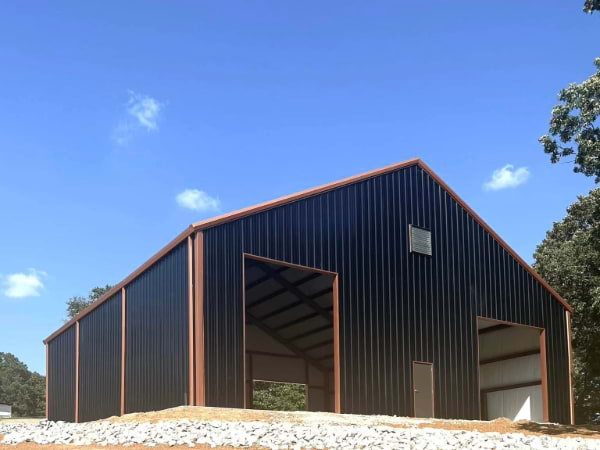 Black siding garage with orange triming, gutters and roof