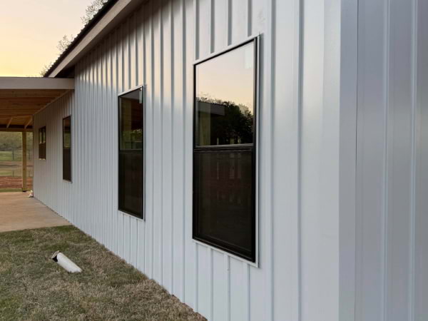 white board and batten siding with black windows