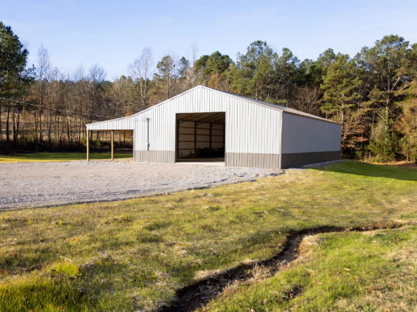 Farm equipment storage building with a light and dark grey siding and roof