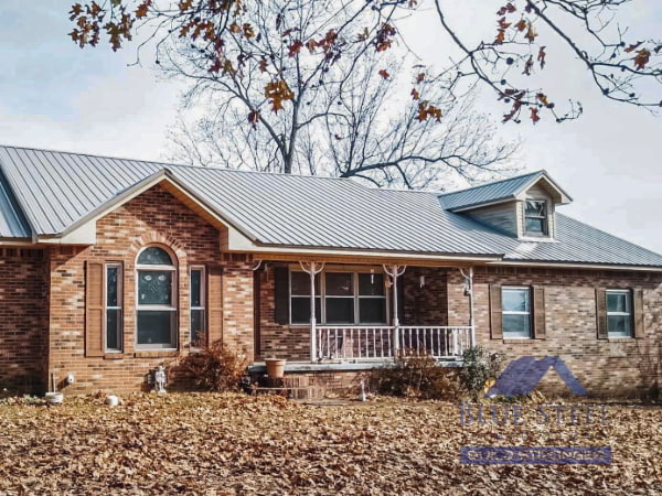multicolor brick house with a gray metal roof from blue steel manufacturing