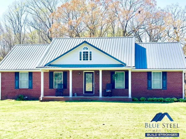 red brick house in a flat land with a black metal roof from blue steel manufacturing