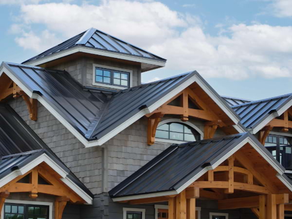 Mechanical seams with black metal roof and decorative wooden trusses