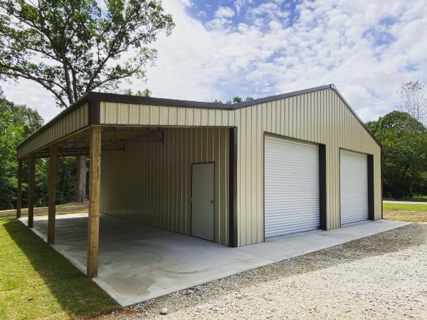 Steel building with yellow siding and a brown roof, white garage doors and house door