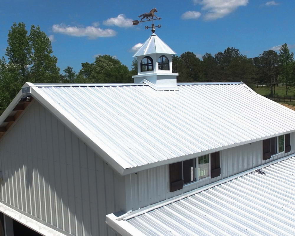 White metal roof with cupola with horse on top