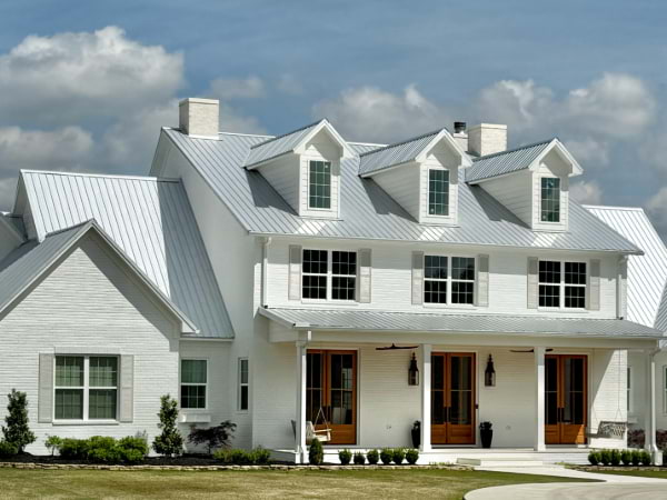 house with white siding with grey metal roof