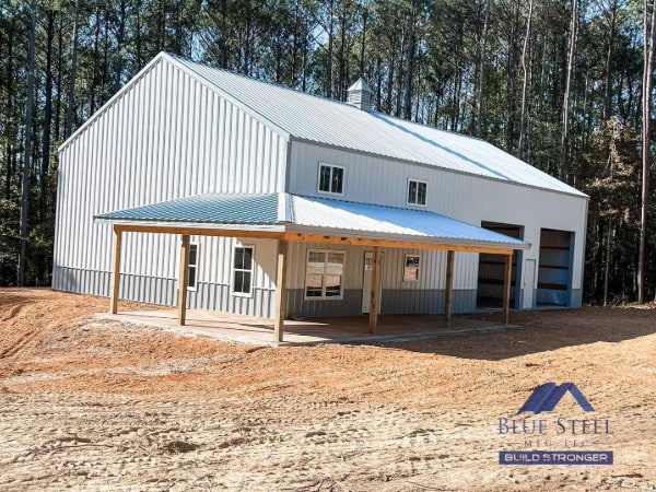 white and grey barndominium from the backside with a garage